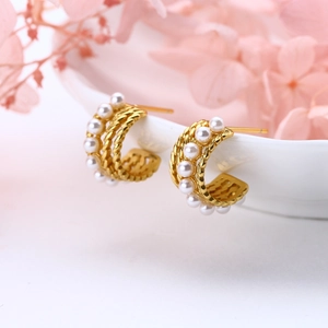 Elegant gold S925 silver C-shape twisted earrings with small pearls on white porcelain