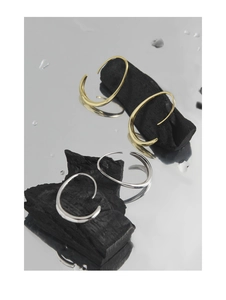Dettaglio macro di orecchini a C in argento sterling oro e argento su pietre nere naturali