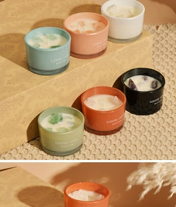 Set of six colorful macaron crystal scented candles in glass jars on a woven mat