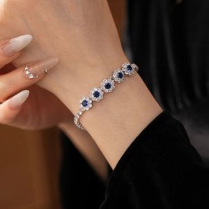 Vue macro détaillée d'un bracelet fleur en zircon avec pierres bleues sur un poignet