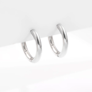 Detailed macro view of silver hoop earrings featuring a high-polish finish and S925 stamp