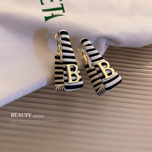 Square faux leather earrings with black white stripes and golden letter B charm