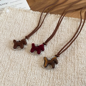 Detailed view of rocking horse pendants in velvet and tiger eye textures on rustic wood