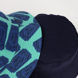 Reversible bucket hat featuring navy cotton canvas and green graphic letter print