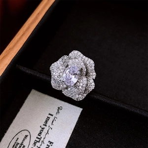 Macro shot of silver camellia ring with oval zircon and pavé petals in a jewelry box