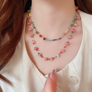 Close-up of double-layer beaded necklace featuring colorful crystal stones on a model