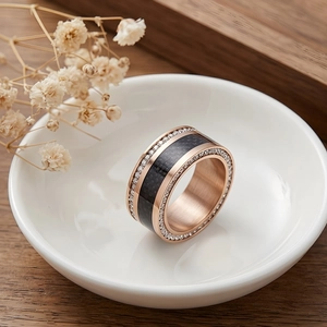 Macro detail of rose gold stainless steel ring with black fiber and sparkling zircons