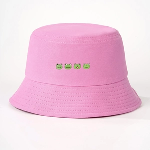 Detailed view of pink cotton bucket hat featuring four cute green frog cartoon patterns