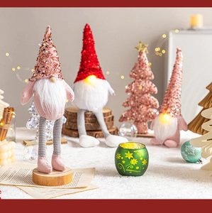 Detail of sequined Christmas gnome plush with LED lights and wooden base on table