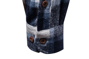 Detailed close-up of blue and grey plaid shirt cuff with flannel texture and buttons