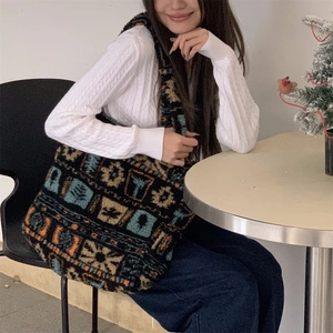 Close-up of large plush tote bag with vintage ethnic prints held in a cozy cafe