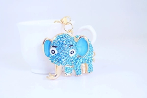 Close-up of golden elephant keychain with blue rhinestones and enamel detail