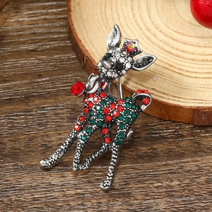 Macro view of a silver deer brooch with sparkling red and green crystals and a crown