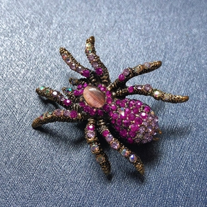 Vintage spider brooch featuring opal stone and purple rhinestones in antique gold finish