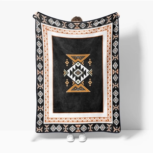 Detail showing soft flannel blanket with orange and black ethnic tribal geometric pattern