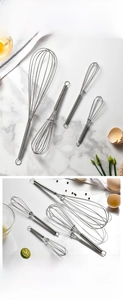 Detail of four stainless steel whisks with 8-wire design on a white marble background