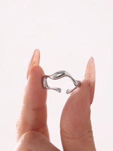Close-up of minimalist silver wavy open ring showing its artistic curved side profile