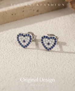 Macro view of S925 sterling silver heart stud earrings with blue and white zircons
