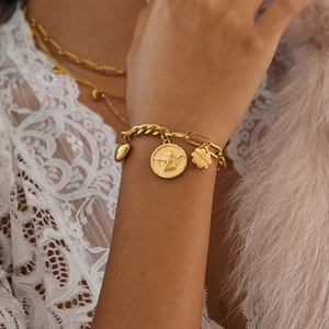 Bracelet doré en acier inoxydable avec trèfle, cœur et médaille d'ange au poignet