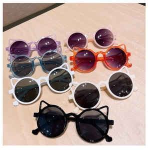 Flat lay of colorful cat-ear round sunglasses for kids on a light wood background