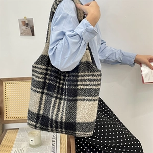 Detail of plush black and white plaid tote bag with soft faux shearling texture
