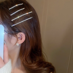 Sparkling rhinestone side hair clip set on model with brown wavy hair and warm background
