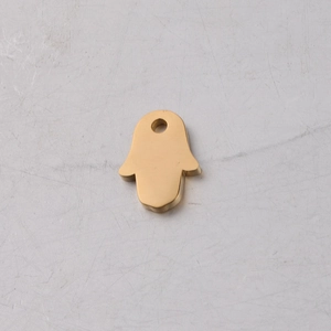 Detail of a polished golden Hamsa Hand pendant made of stainless steel with mirror finish