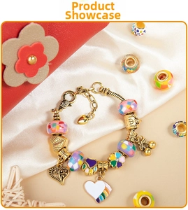 Detail of pink charm bracelet set with colorful enamel beads and golden pendants