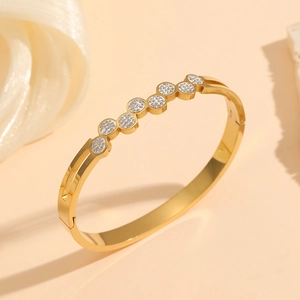 Detailed view of gold plated titanium steel bangle with hollow design and sparkling crystals