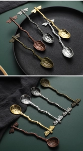 Detailed macro view of vintage branch-style spoons with dragonfly and leaf designs
