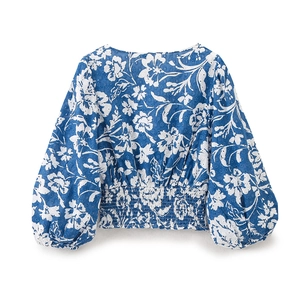 Dettaglio del top a fiori blu con vita elasticizzata a punto smock e maniche lunghe a sbuffo