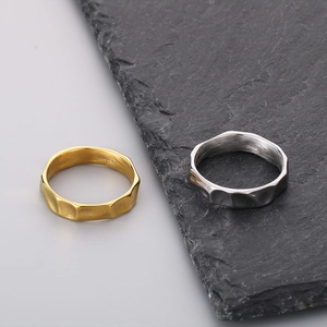 Close-up of gold and silver stainless steel rings with irregular hammered texture