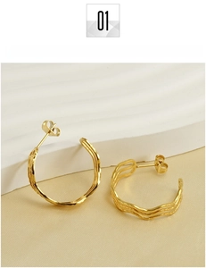 Macro detail of 18k gold plated stainless steel hoop earrings with textured wave design