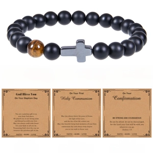 Detail of matte black stone bead bracelet with cross charm and religious blessing cards