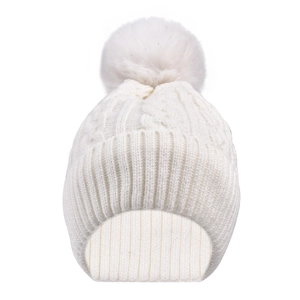 Detail of cable knit pattern and large faux fur pompom on winter beanie hat