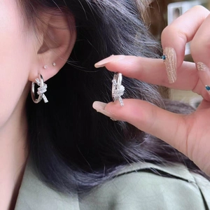 Boucles d'oreilles nœud en argent avec zircons étincelants au style minimaliste