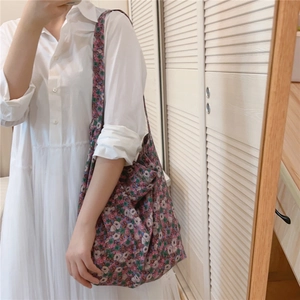 Detail of vintage floral print cotton tote bag worn with a white vintage dress
