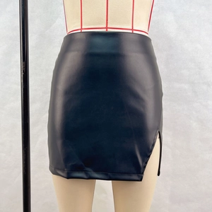 Detail of high-waist black PU leather mini skirt showing side slit and smooth texture