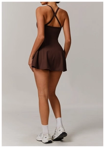 Detail of cross-back straps and pleated hem on a brown athletic tennis dress