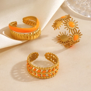 Three-piece gold-finish stainless steel ring set with orange enamel and sunburst motif