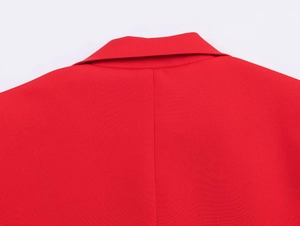 Detail of red blazer collar and shoulders with clean stitching and twill fabric texture