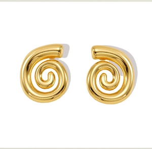 Dettaglio macro di orecchini a spirale con finitura in acciaio inossidabile placcato oro 18k