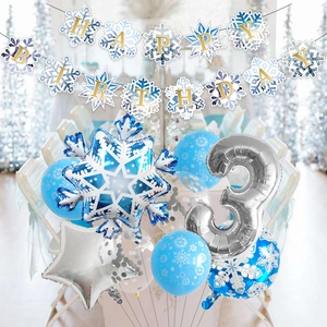 Blue snowflake themed birthday party set with foil balloons and happy birthday banner