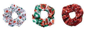Detailed view of three festive Christmas satin scrunchies with holly and snowflake patterns
