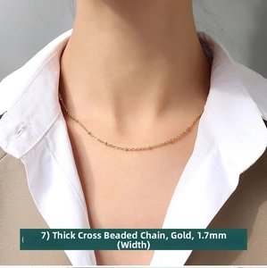 Detail of 1.7mm wide gold cross bead chain necklace shown on a model's neck