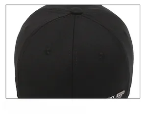 Detail of black baseball cap showing cotton twill texture and metal fashion label
