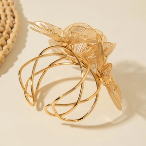 Exaggerated gold open cuff bracelet featuring an intricate hollow floral design for women
