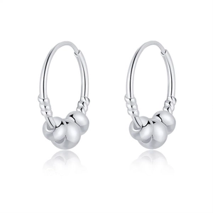 Vue macro de créoles en argent S999 avec trois billes polies sur un fond blanc pur
