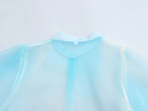 Dettaglio del colletto della camicia in organza celeste e trama con palma tropicale