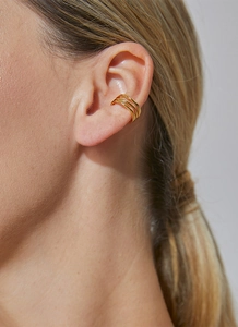 Detail of three-layer gold-plated ear cuff showing the layered design on a model